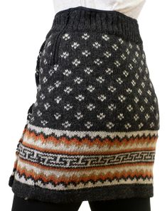 the back of a woman's sweater with an orange, white and black pattern