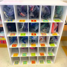 a white shelf filled with lots of different types of bags and numbers on it's sides