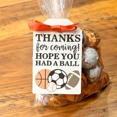 a bag filled with lots of chocolates sitting on top of a wooden table next to a sign that says thanks for coming hope you had a ball