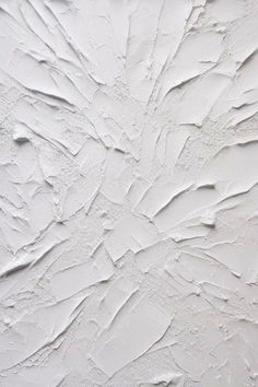 a white wall that has some paint peeling off of it's walls and is being used as a background