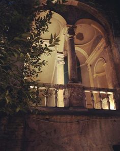 an old building with columns and arches lit up by the sun shining through the window