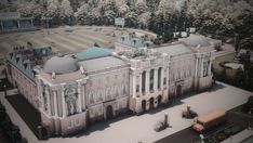 an aerial view of a large building in the middle of a park with lots of trees