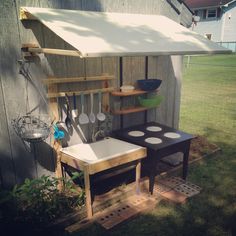 an outdoor kitchen with pots, pans and utensils