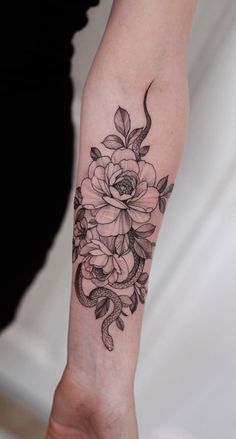 a woman's arm with a flower tattoo on it