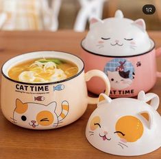 three bowls with cats on them sitting on a table