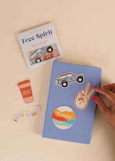 a hand is pointing at a book with stickers on it