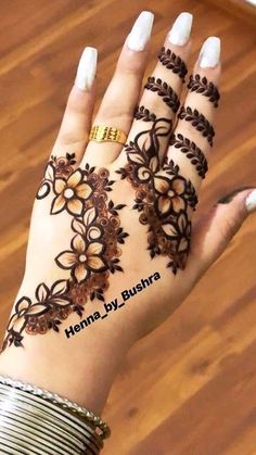 hendi design on the palm of a woman's hand with flowers and leaves