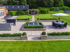 an aerial view of a garden with seating and tables, surrounded by green lawning