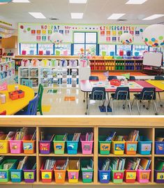 an empty classroom filled with lots of colorful bins and desks full of children's books