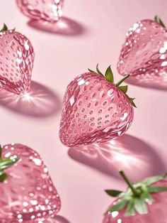 some very pretty pink strawberries on a light pink surface with shiny lights around them