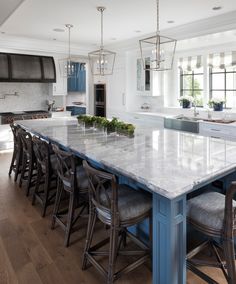 a large kitchen with an island in the middle and lots of counter space on one side