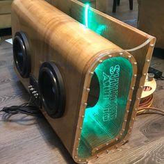 a wooden speaker with green lights on it's front and back sides sitting on a table