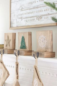 christmas stockings hanging from hooks on a mantel in front of a sign and fireplace