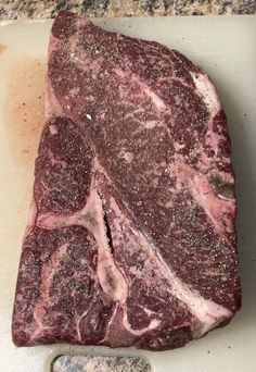 a piece of raw meat sitting on top of a cutting board