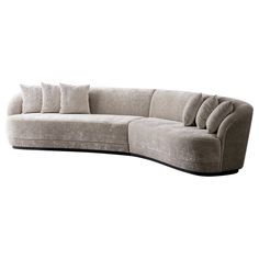 a large sectional couch with pillows on it's back and arms, in grey velvet