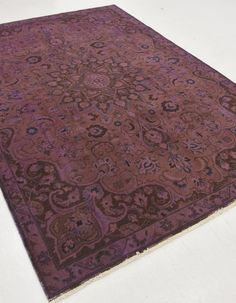 a large purple rug with an intricate design on the top and bottom, sitting on a white floor