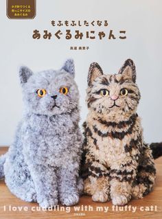 two cats sitting next to each other on top of a wooden table in front of an advertisement