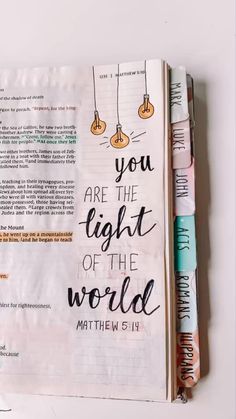 an open bible with the words you are the light of the world