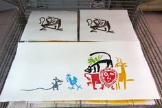 three different colored drawings on white paper in a cage