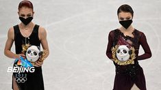 two women wearing face masks and holding balls