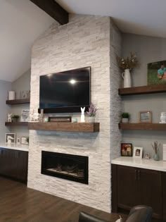 a living room with a large flat screen tv mounted on the wall above a fireplace