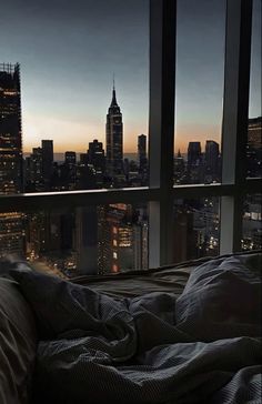 a bedroom with a view of the city at night