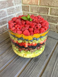 a fruit salad in a glass bowl on a wooden table