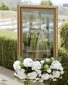 white flowers are in front of a sign that says, all because two people fell in love