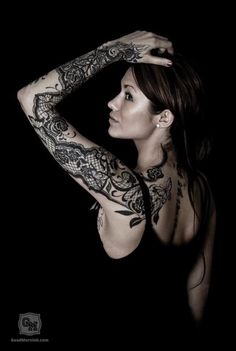 a woman with tattoos on her arms and shoulder