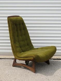 a green chair sitting in front of a garage door