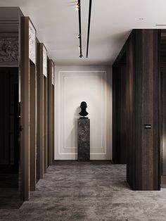 the hallway is lined with tall wooden doors and marble busturizer in the center