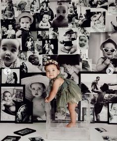 a baby is standing in front of many pictures