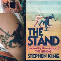 a woman holding a book with tattoos on her arm and the cover of the novel, the stand