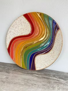 a multicolored plate sitting on top of a counter next to a white wall