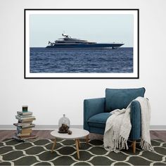 a living room with a blue chair and a large boat in the water