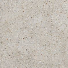 a close up view of the surface of a white marble slab with brown speckles