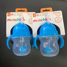 two blue munch n sippy cups sitting next to each other on a table