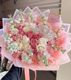 a bouquet of pink and white flowers with a tiara