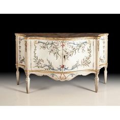 an ornate white and gold painted cabinet with floral designs on the doors, drawers and legs