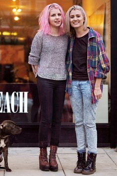 two young women standing next to each other in front of a store with a dog