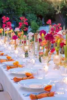 a long table is set up with flowers and candles for an outdoor dinner or party