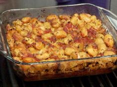 a casserole dish sitting on top of an oven rack filled with potatoes and bacon