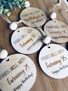 personalized wooden tags for birthdays with names and date on them, hanging from a table