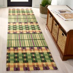 a green, yellow and purple checkered rug on the floor in a living room