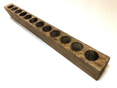 a wooden object with eight holes in it