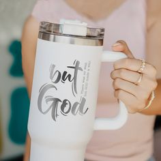 a woman holding a white coffee cup with the words out god on it