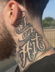 a man with a neck tattoo that says i am fit on the side of his head