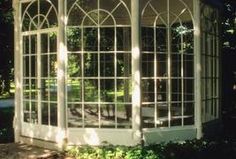 a white gazebo sitting in the middle of a lush green park