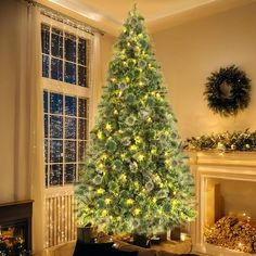 a lit christmas tree in front of a fireplace