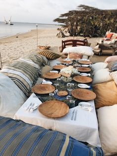 a table set up on the beach for an outdoor dinner